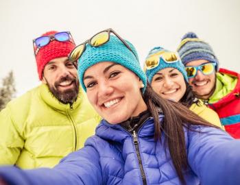 A family wearing winter gear and smiling at the camera
