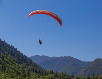 Paraglider surrounded by blue sky