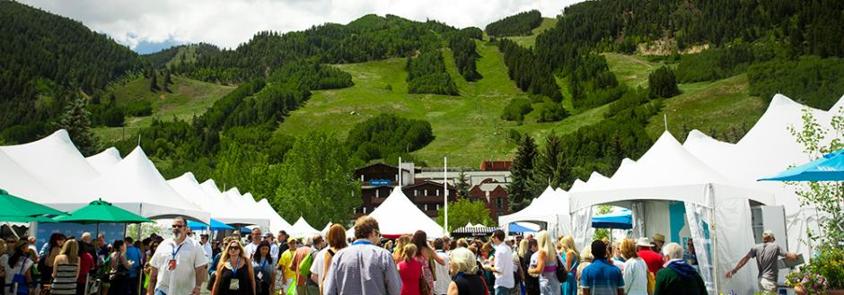 A crowd with white tents looking at Aspen Mountain