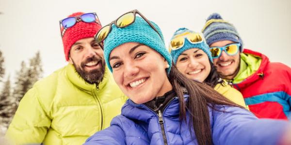 A family wearing winter gear and smiling at the camera