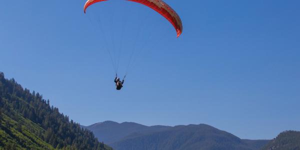 Paraglider surrounded by blue sky