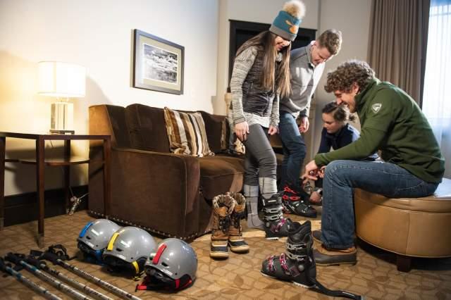 ski butlers helping skiers try on gear