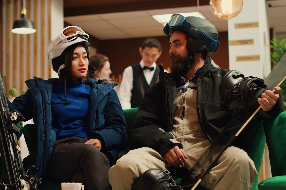 Travelers arrive in cozy ski resort lobby